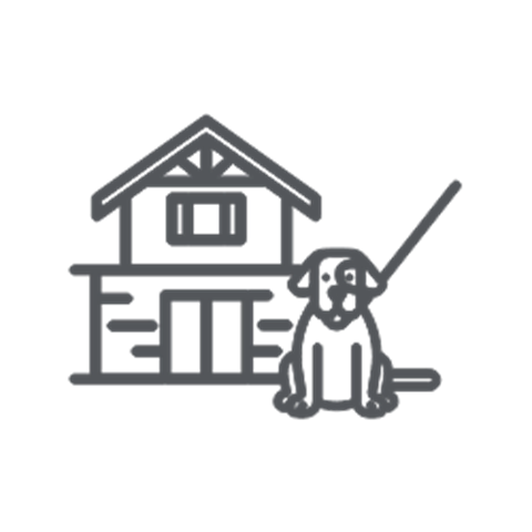 Dog on a leash in front of a house.
